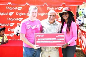 Digicel CEO Kevin Kelly (left) and Head of Marketing Ms. Jacqueline James (right) handing over the cheque to Dr. Syed Ghazi of the Cancer Institute of Guyana.