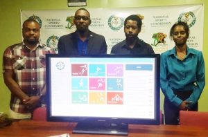 Director of Sport, Christopher Jones (second left), IntellectStorm’s, Rowen Willabus, Assistant Director of Sport, Melissa Robertson (right) and Commissioner, Edison Jefford (left) display the interactive Home Page for the NSC Database on sport and athletes.