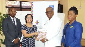 Finance Minister Winston Jordan receiving the CHDR 2016 Report from Mikiko Tanaka UN Resident Coordinator in the company of Kenroy Roach, UNDP Regional Advisor (at extreme left) and Dr. Barbara Reynolds, Deputy Vice-Chancellor, UG (at extreme right)