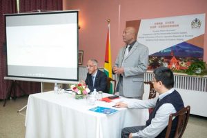 Business Minister Dominic Gaskin (l) and Ambassador to China, Bayney Karran (standing) during the recent forum.