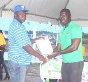 A farmer collecting his land lease from Deputy CEO of GKDA, Dr. Walrond Powered 