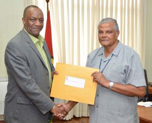 Minister of State, Joseph Harmon, hands over the Terms of Reference (TOR) to Major General Retd. Joe Singh, MMS for the investigations into the allegations of corruption and misconduct made by Mr. Kenwin Charles against members of the Guyana National Broadcasting Association (GNBA) Board.