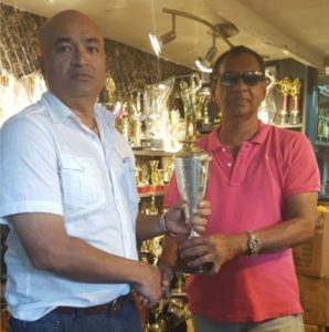 President Oncar Ramroop (left) receives a trophy, the symbol of Trophy Stall’s sponsorship from Mr. Ramesh Sunich, CEO of Trophy Stall.