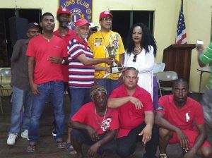 President of the GDA Faye Joseph (standing right) hands over the winning trophy and first prize to members of the victorious Sheriff Street Swagga Boys team.