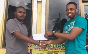 Dukquan Rose (left) of Broad Money Spare Parts hands over cheque to New Era Director Shareef Major.