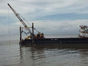 Work being conducted in the Demerara River yesterday on the GAICO barge to repair the damaged submarine power cable.