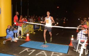 Lionel D’Andrade bursts through the tape to win the Srefidensi Marathon in Suriname.