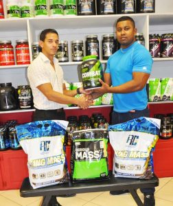 Manager of Fitness Express Jamie Mc Donald (left) hands over the sponsorship to Videsh Sookram.