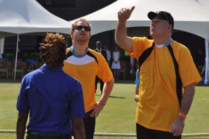The Umpire and Prince Harry watch as St Lucian PM Allen Chastanet toss the coin yesterday to start the festival game. (Sean Devers photo)