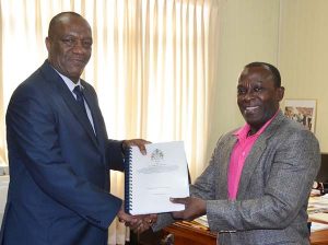 Brigadier (Retd.) Edward Collins handing over the final report to Minister of State, Joseph Harmon, yesterday.