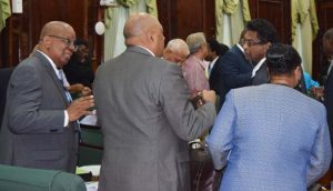 Finance Minister, Winston Jordan (l) speaking with his colleague ministers on Monday at the Parliament Buildings.
