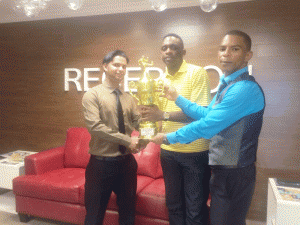 Vickash Persaud (left) Senior Rep and Marlon Hendricks (right) Agency Manager of Nalico Nafico, present the Female 1st Place Trophy to Aubrey Major Jnr., New Era Director.