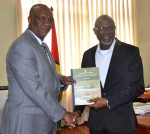 Minister of State Joseph Harmon receiving the final report into Puruni Mining Pit Collapse from Rear Admiral (retd) Gary Best, at his office at Ministry of the Preside. 