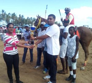  Photos saved as Mohini Persaud presents the winning trophy to Nazrudeen  Mohamed for Appealing Harvest’s victory. 