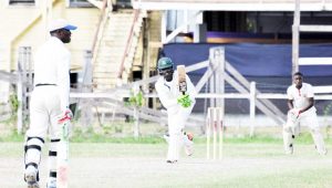  Steven Harris on drives on his way to 146 as Jason McCalmount (44) watches from the non-striker’s end at Police yesterday. (Sean Devers photo)