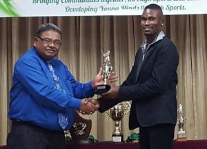 Travis Blyden (right) accepts one of the prizes from the Marketing manager of the Rahamut’s Group of Companies Russell Ramlogan. 