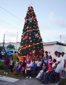 Lights On! The gleeful  children surrounded by  hospital officials at the  Christmas tree light up