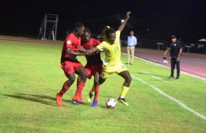 Guyana’s Kadell Daniel (right) being jostled by two Antiguan defenders last night.