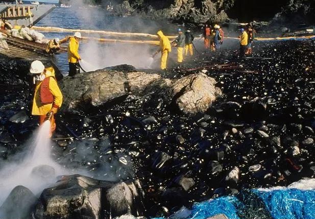 Exxon Valdez oil spill workers and maxi-barge hose beach after Corexit test on Quayle beach, Smith Island in Prince William Sound, Alaska, US, on 7 August 1989. Photograph: Alaska Resources Library and Information Services (Arlis) Photograph: ARLIS