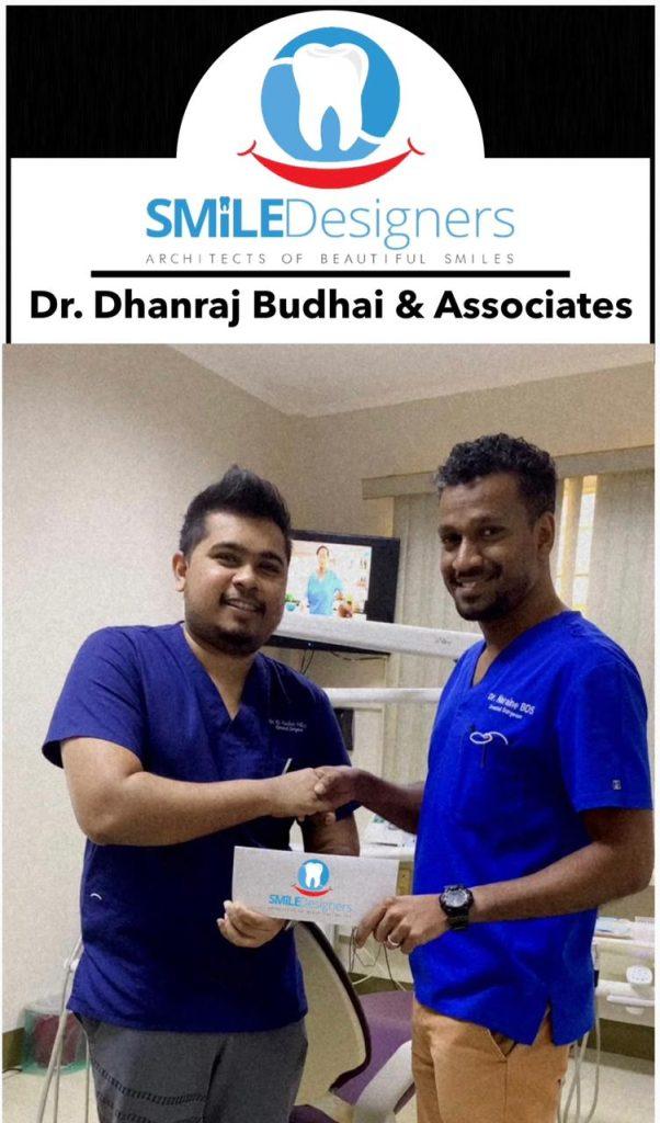 Dr. Budhai managing director of Smile Designers left handing sponsorship to Mikhel Narine.