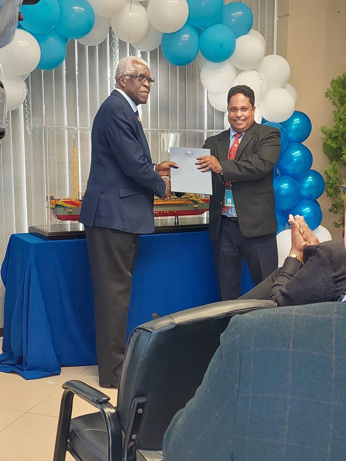 The country’s first ever Heli-deck Inspector, Adrian Bassier (right) receiving his certificate on Tuesday from Director General of the Guyana Civil Aviation Ceremony (GCAA).