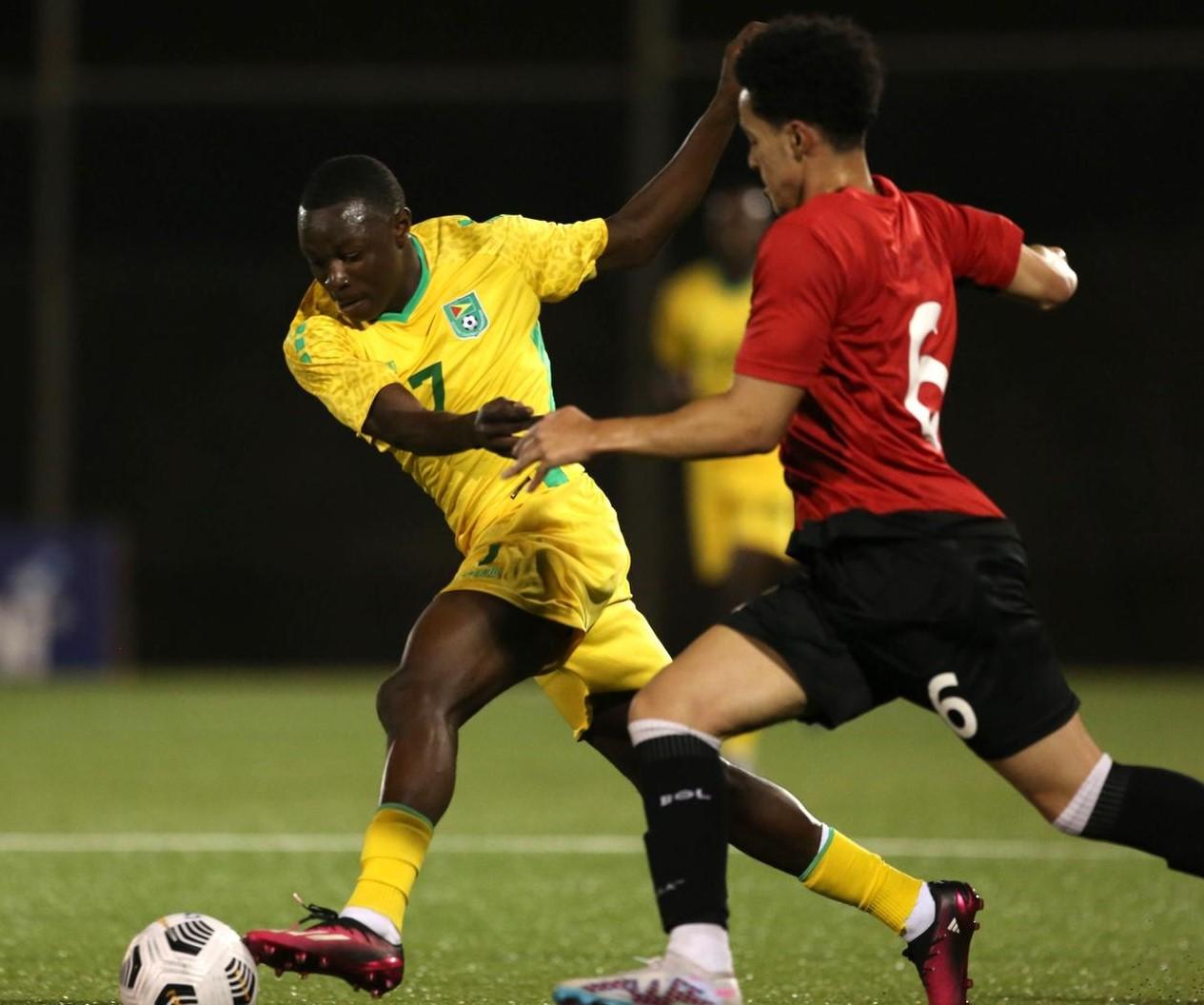 Guyana’s Omari Glasgow evades Montserrat’s Brandon Barzey during their clash at Wildey Turf inside the Sir Garfield Sobers Sports Complex in Barbados.
