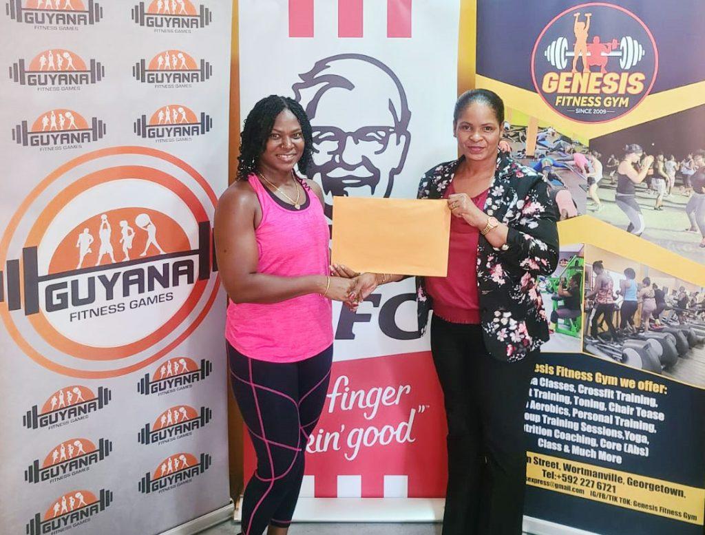 Coordinator Noshavyah King (left) collects the sponsorship from KFC Guyana Marketing Manager Pamella Manasseh