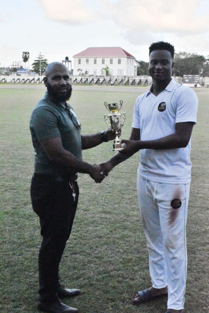 Ronaldo Ali Mohammed receives his Man of the Match award from GCB official.