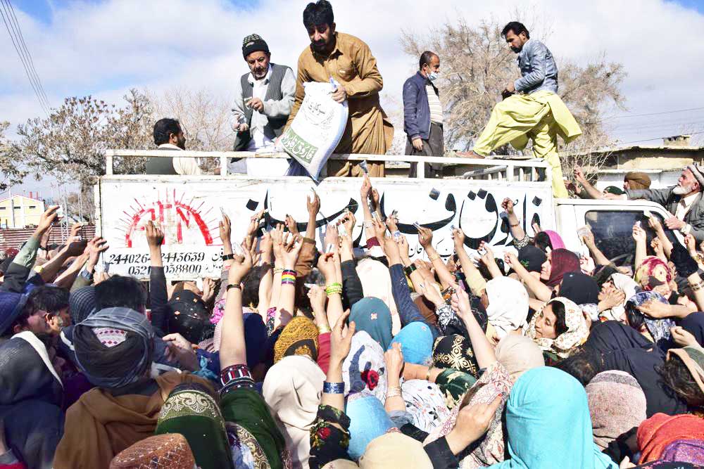 People jostle each other to buy subsidized sacks of wheat flour in Quetta, Pakistan, Thursday, Jan. 12, 2023, after a recent price hike of flour in the country. An Associated Press analysis of a dozen countries most indebted to China - including Pakistan, Kenya, Zambia and Laos - found the debt is consuming an ever-greater amount of tax revenue needed to keep schools open, provide electricity and pay for food and fuel. (AP Photo/Arshad Butt, File)