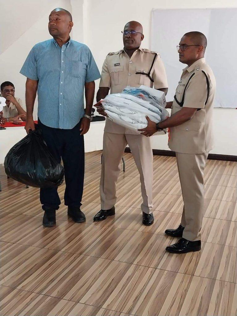 RHTYSC secretary Hilbert Foster hands over cricket gears and toys to Commander Shivpersaud Bacchus and Division Two Head Michael Newland.