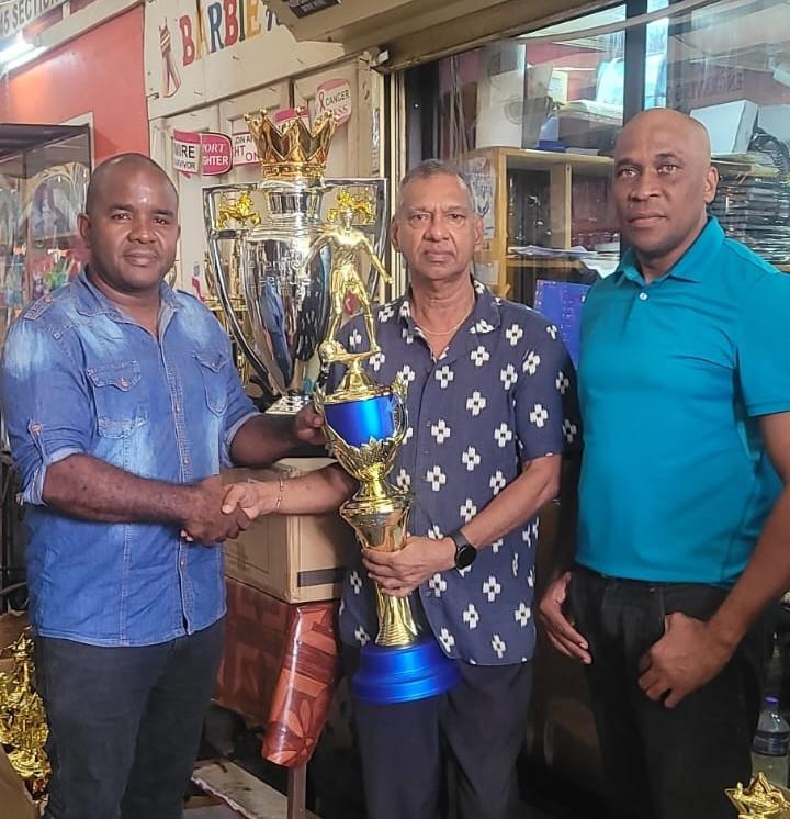 Trophy Stall’s Ramesh Sunich makes his presentation to organisers Keeran Williams and Stanley Lancaster.