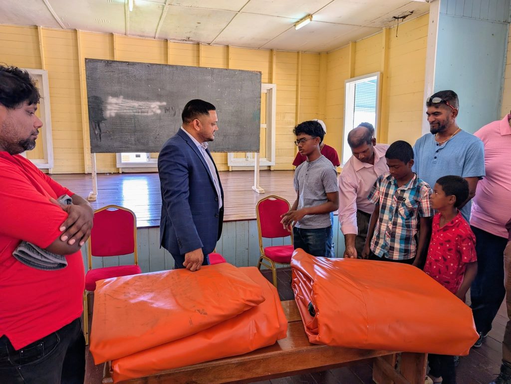 Minister Vickram Bharrat hands over cricket gear, covers to Port Mourant Cricket Club