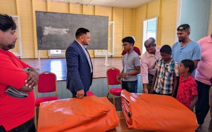 Minister Vickram Bharrat hands over cricket gear, covers to Port Mourant Cricket Club
